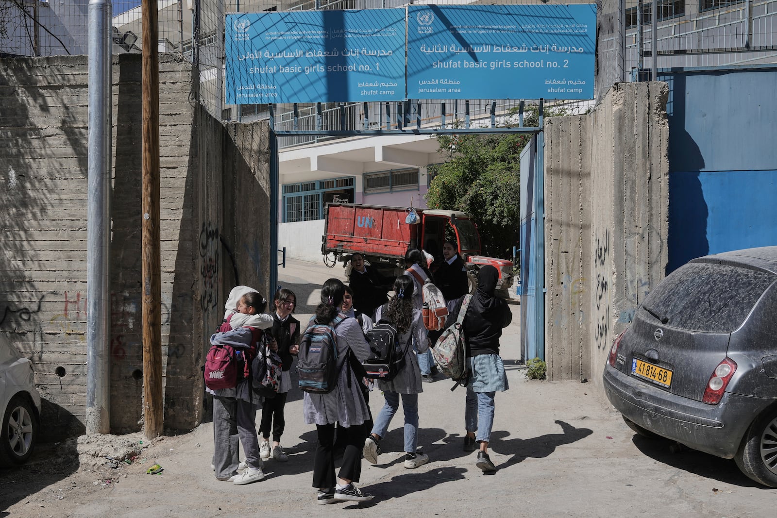 Students walk out of UNRWA Girls School run by the U.N. agency for Palestinian refugees in the Shuafat Refugee Camp in east Jerusalem, Thursday, May 8, 2025. After Israeli forces ordered the closure of six of its schools in east Jerusalem Thursday. (AP Photo/Mahmoud Illean)