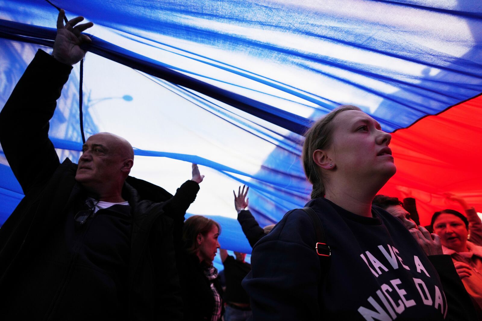 People hold a giant Serbian flag ahead of a big counter-opposition protest rally planned to stage over the weekend in downtown Belgrade, Serbia, Friday, April 11, 2025. (AP Photo/Darko Vojinovic)
