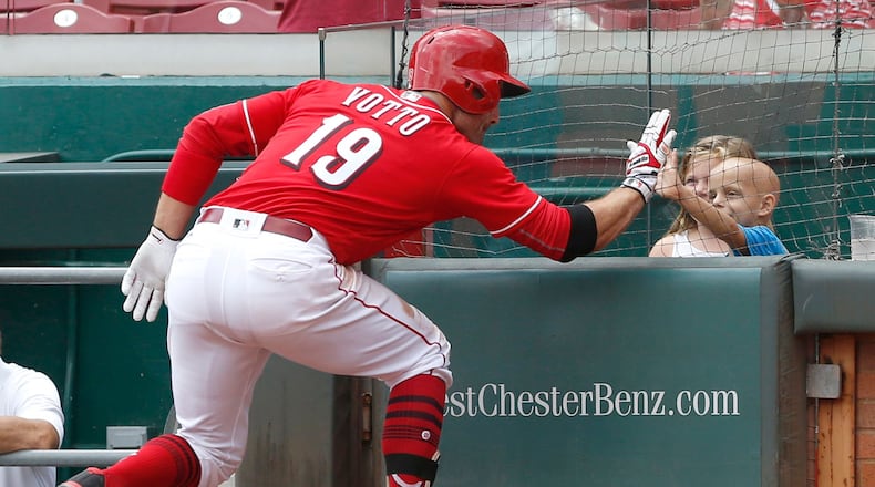 Reds first baseman Joey Votto high fives six-year old Walter Herbert (right) after hitting a solo home run.