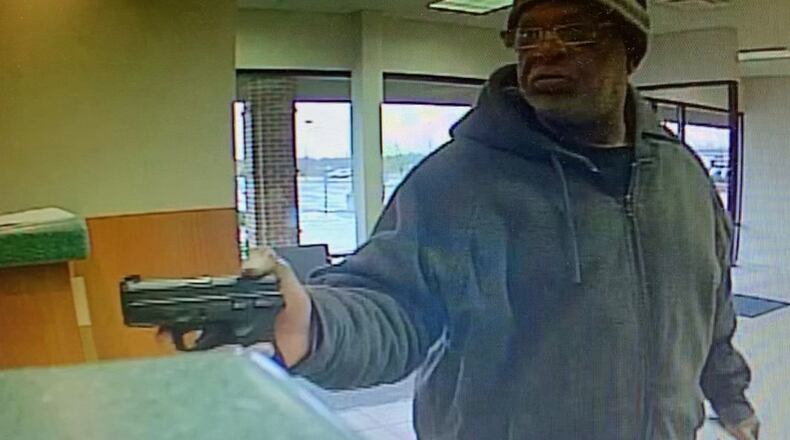 Surveillance video shows a man, later identified as Samuel Hayes of Dayton, pointing a handgun during the Jan. 11, 2020, robbery of Universal 1 Credit Union on Harshman Road in Dayton. CONTRIBUTED