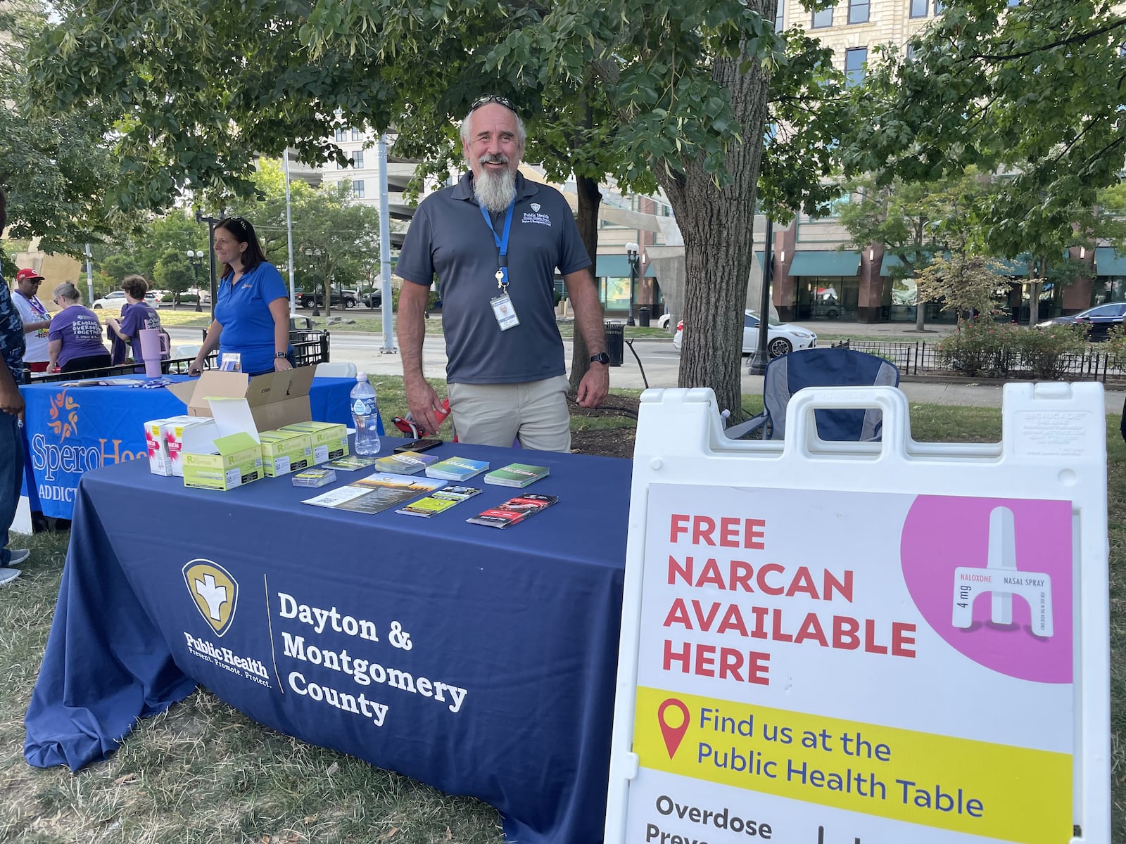 A Dayton & Montgomery County Public Health employee stands behind the Public Health Table at Overdose Awareness Day at Levitt Pavilion in 2024. Public Health - Dayton & Montgomery County, along with other area health departments, can provide people with free Narcan, also called naloxone, which is a drug that can reverse the effects of an opioid overdose. CONTRIBUTED