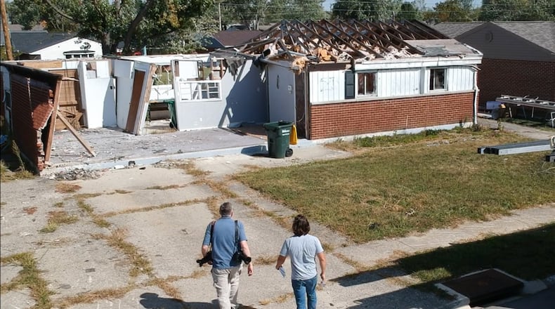Dayton Daily News reporters Chris Stewart, left, and Josh Sweigart are retracing the path of a devastating EF4 Memorial Day tornado that cut across Montgomery County. They are seen at a house in Brookville's Terrace Park neighborhood. CHUCK HAMLIN / STAFF