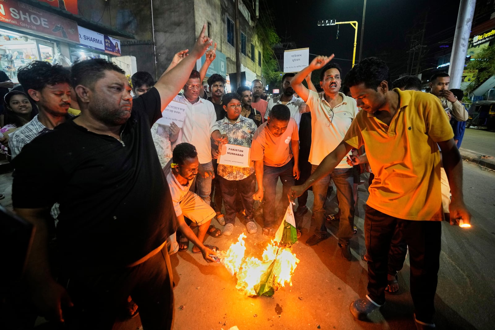 People burn a Pakistani flag in protest against the killing of tourists by militants a day after militants indiscriminately opened fire on tourists near Pahalgam in Indian controlled Kashmir, in Guwahati, India, Wednesday, April 23, 2025. (AP Photo/Anupam Nath)