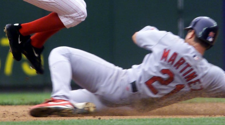 Gookie Dawkins jumps over Tino Martinez as the Reds try to complete a double play. DDN FILE