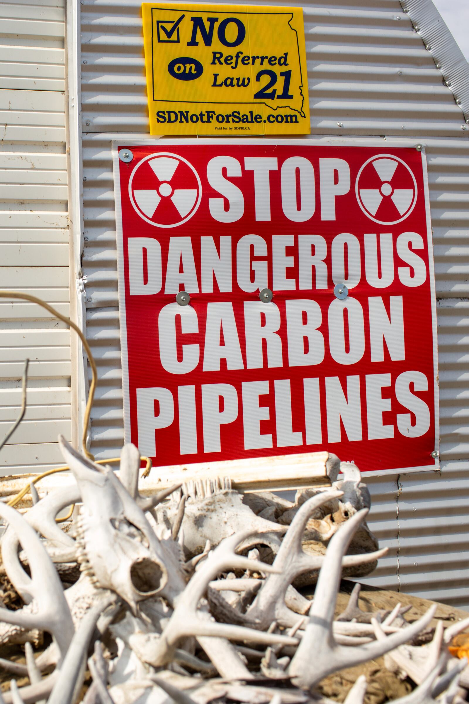 A sign protesting carbon pipelines is displayed on a building at Jared Bossly's ranch in Mansfield, S.D., on Tuesday, March 11, 2025. (AP Photo/Nicole Neri)