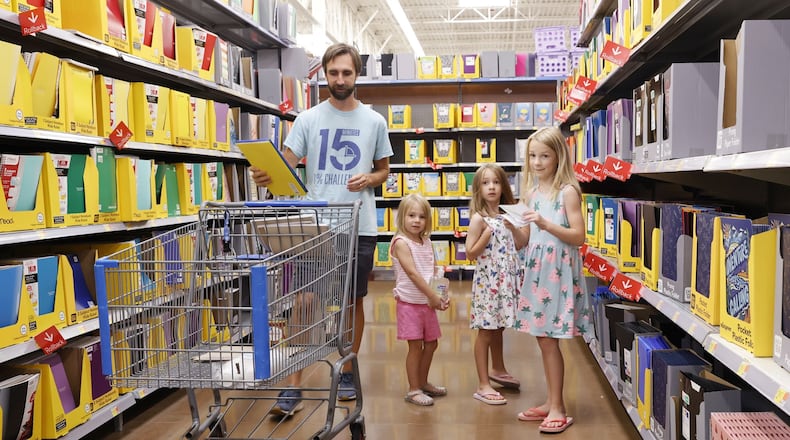 Zack Hinger shops for school supplies with daughters Lily, 8, Theresa, 6, and Cece, 4, at Walmart Tuesday, July 23, 2024 in West Chester Township. Ohio's sales tax holiday is July 30 to Aug. 8 running 10 days instead of 3 days from last year and includes more than just school supplies and clothing. NICK GRAHAM/STAFF