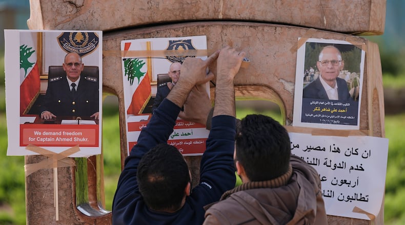 Family members of retired Lebanese officer Ahmed Shukr, hang posters of him during a gathering outside the headquarters of the U.N. Economic and Social Commission for Western Asia, ESCWA, in Beirut, Lebanon, Friday, Feb. 13, 2026. (AP Photo/Bilal Hussein)