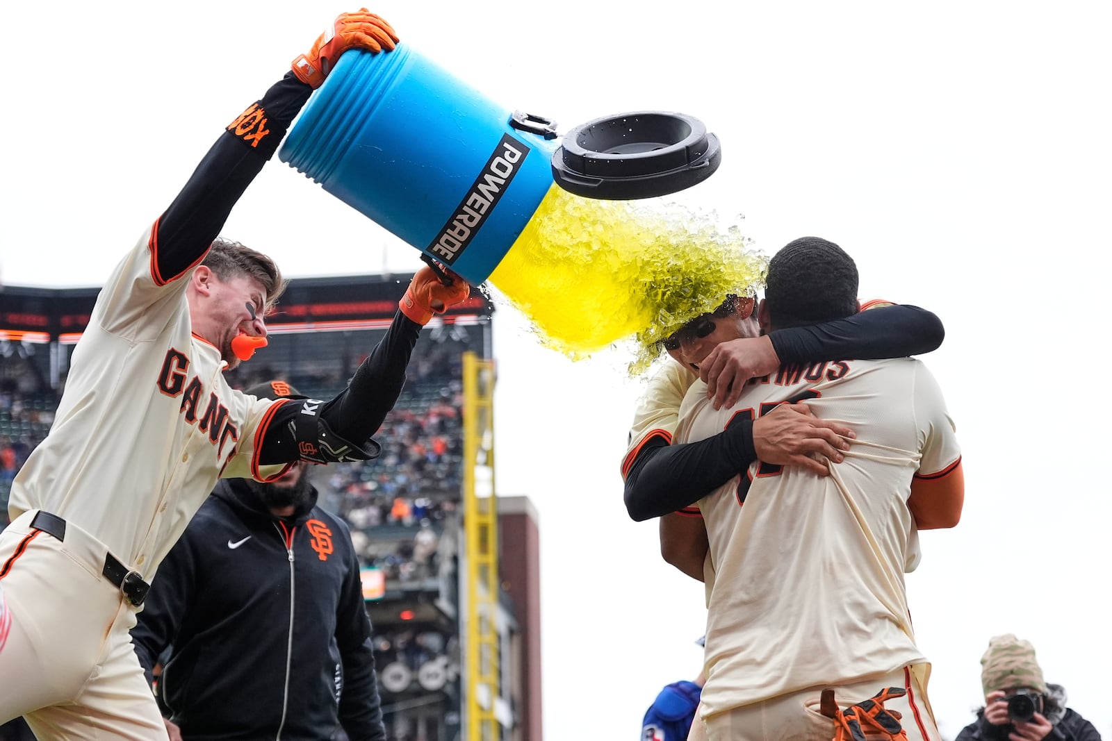 San Francisco Giants' Christian Koss, left to right, douses Jung Hoo Lee and Heliot Ramos after Ramos scored the game-winning run against the Texas Rangers after a baseball game Sunday, April 27, 2025, in San Francisco. (AP Photo/Godofredo A. Vásquez)