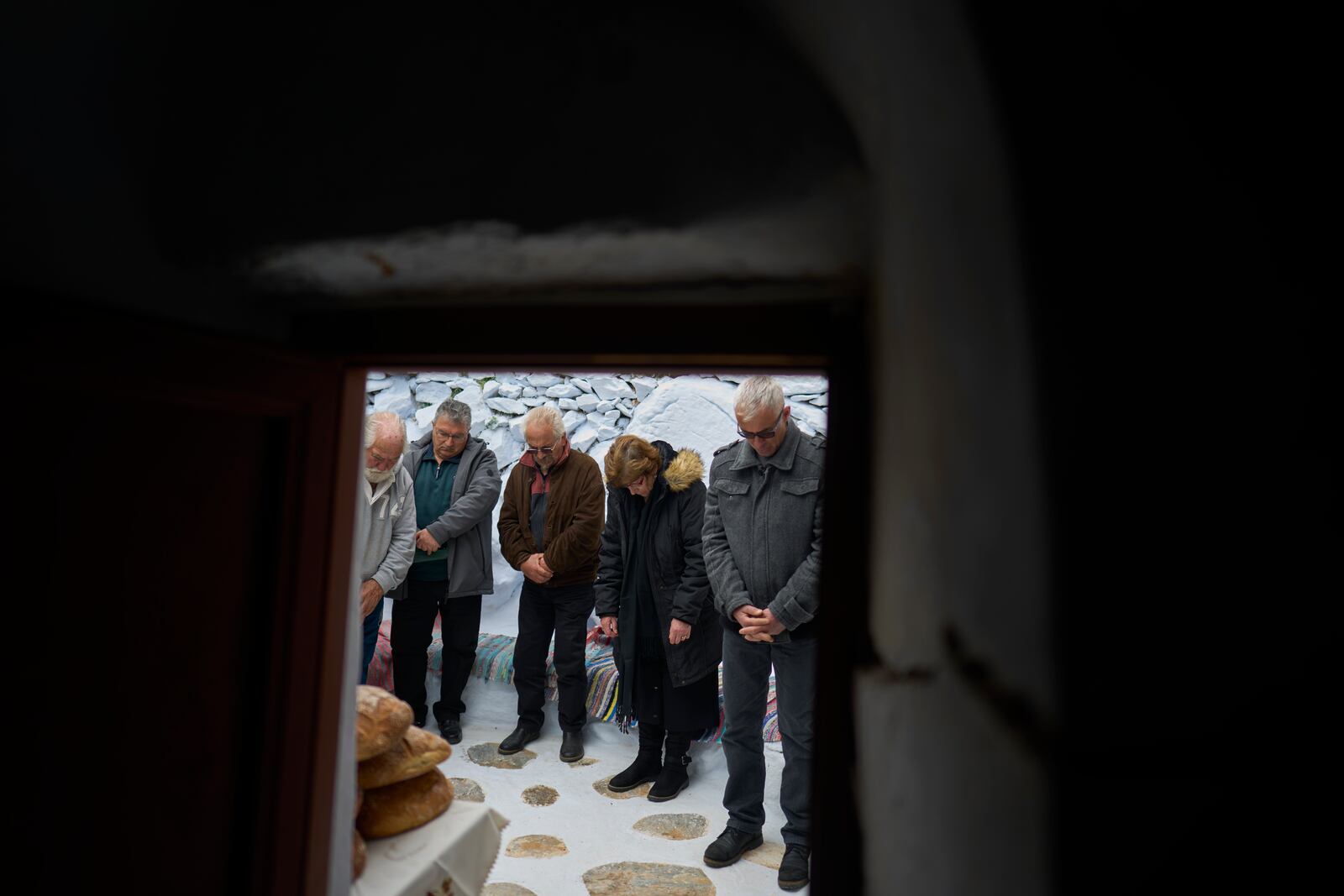 The faithful stand outside the chapel of Panagia Evangelistria, in Amorgos island, Greece, as Orthodox Christian monk Father Spyridon of Amorgos conducts the Divine Liturgy, on Tuesday, March 25, 2025. (AP Photo/Petros Giannakouris)