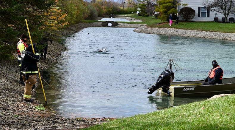Rescue workers searched a pond Thursday at a West Chester Twp. apartment complex for a missing 7-year-old boy with a boat drone. MICHAEL D. PITMAN/STAFF