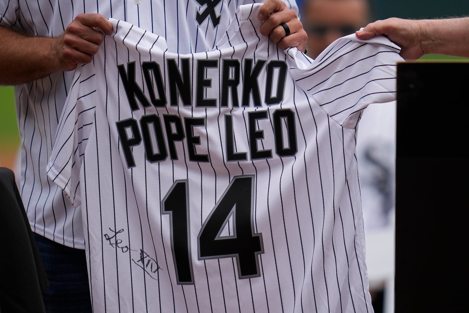 Cardinal Blase Cupich, right, presents former Chicago White Sox player Paul Konerko with a jersey signed by Pope Leo XIV during a ceremony honoring the 2005 World Series Champions before a baseball game between the Cleveland Guardians and Chicago White Sox, Saturday, July 12, 2025, in Chicago. (AP Photo/Erin Hooley)