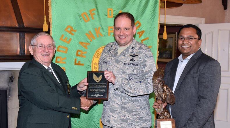 Jim DeStout, left, adjutant, Flight 9 – Frank P. Lahm Order of Daedailians, presents the 2017 Daedalian Colonel Franklin C. Wolfe Weapon Systems Award plaque to Col. Anthony Thomas, Air Force Life Cycle Management Center advisor to the Light Attack Experiment Phase 1 team, and trophy to Dr. Ravi Penmetsa, Light Attack Experiment Team Lead Sept. 20. The combined efforts of personnel from the Air Force Life Cycle Management Center and Air Force Research Laboratory contributed to the overall success of the Phase I Experiment effort, which, in turn, paved the way for the Phase II Experiment in 2018 and the further development and maturation of the USAF Light Attack Aircraft acquisition strategy. (U.S. Air Force photo/Al Bright)