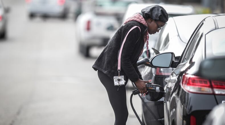 Jordan Bernard unplugs her KIA Optima hybrid from a charging station near the intersection of Patterson and Monument in downtown Dayton on Tuesday March 9, 2021. Nearly 30 sites in the Dayton area have been awarded state funds for electric vehicle charging ports as part of $3.25 million in grants announced by the Ohio Environmental Protection Agency.