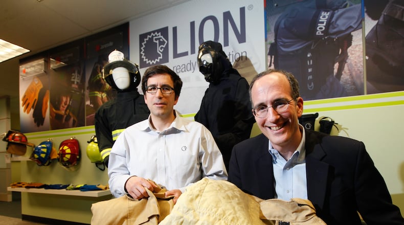 LION CEO Steve Schwartz, right, and his brother Andy Schwartz, corporate counsel, are the grandsons of founder William Lapedes. The two are seen with the company’s Janesville turnout for firefighters that incorporates a new Kevlar filament and Nomex blend.CHRIS STEWART / STAFF