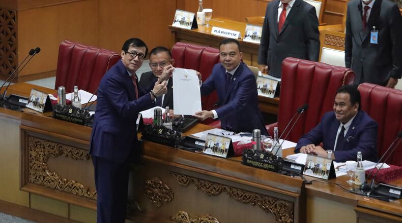 FILE - Indonesian Law and Human Right Minister Yasonna Laoly, left, pose for the media with Deputy House Speaker Sufmi Dasco Ahmad, center, during a session ratifying the country's new criminal code at the parliament building in Jakarta, Indonesia, Tuesday, Dec. 6, 2022. (AP Photo, File)