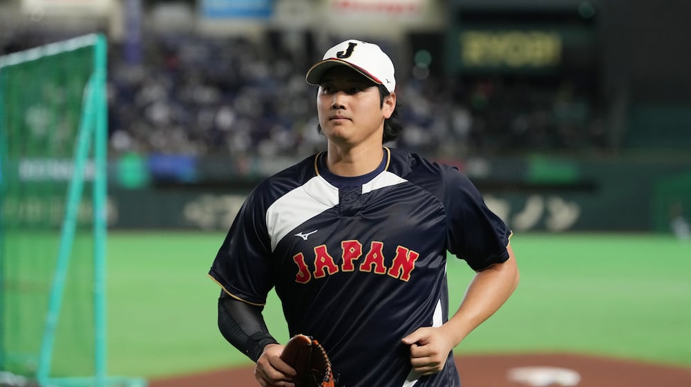 Japan's Shohei Ohtani returns to his team's dugout after warming up before the start of a World Baseball Classic game between Japan and Australia on Sunday, March 8, 2026 in Tokyo. (AP Photo/Hiro Komae)