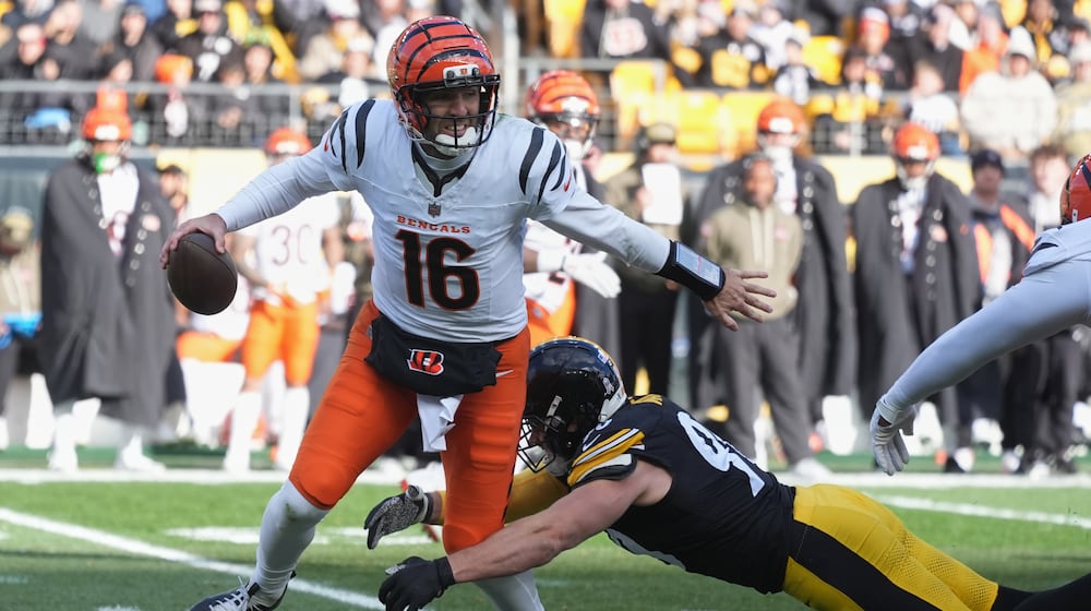 Cincinnati Bengals quarterback Joe Flacco (16) avoids a tackle by Pittsburgh Steelers linebacker T.J. Watt (90) during the first half of an NFL football game Sunday, Nov. 16, 2025, in Pittsburgh. (AP Photo/Gene J. Puskar)