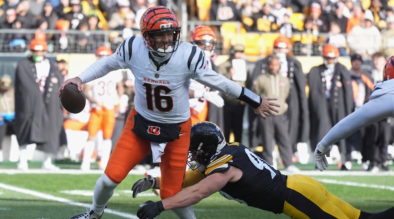 Cincinnati Bengals quarterback Joe Flacco (16) avoids a tackle by Pittsburgh Steelers linebacker T.J. Watt (90) during the first half of an NFL football game Sunday, Nov. 16, 2025, in Pittsburgh. (AP Photo/Gene J. Puskar)