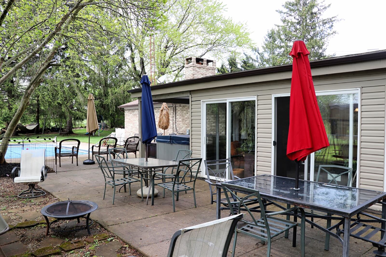 The half-acre lot has a fenced back yard with a spacious concrete patio, covered patio and in-ground swimming pool. Lawn space is hidden from neighbors by mature trees. CONTRIBUTED PHOTO BY KATHY TYLER
