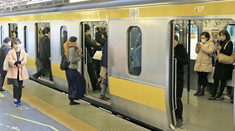 Passengers at JR Shinjuku Station in Tokyo stand in an East Japan Railway Co. train whose seats have been folded up during rush hour. PHOTO: The Japan News-Yomiuri