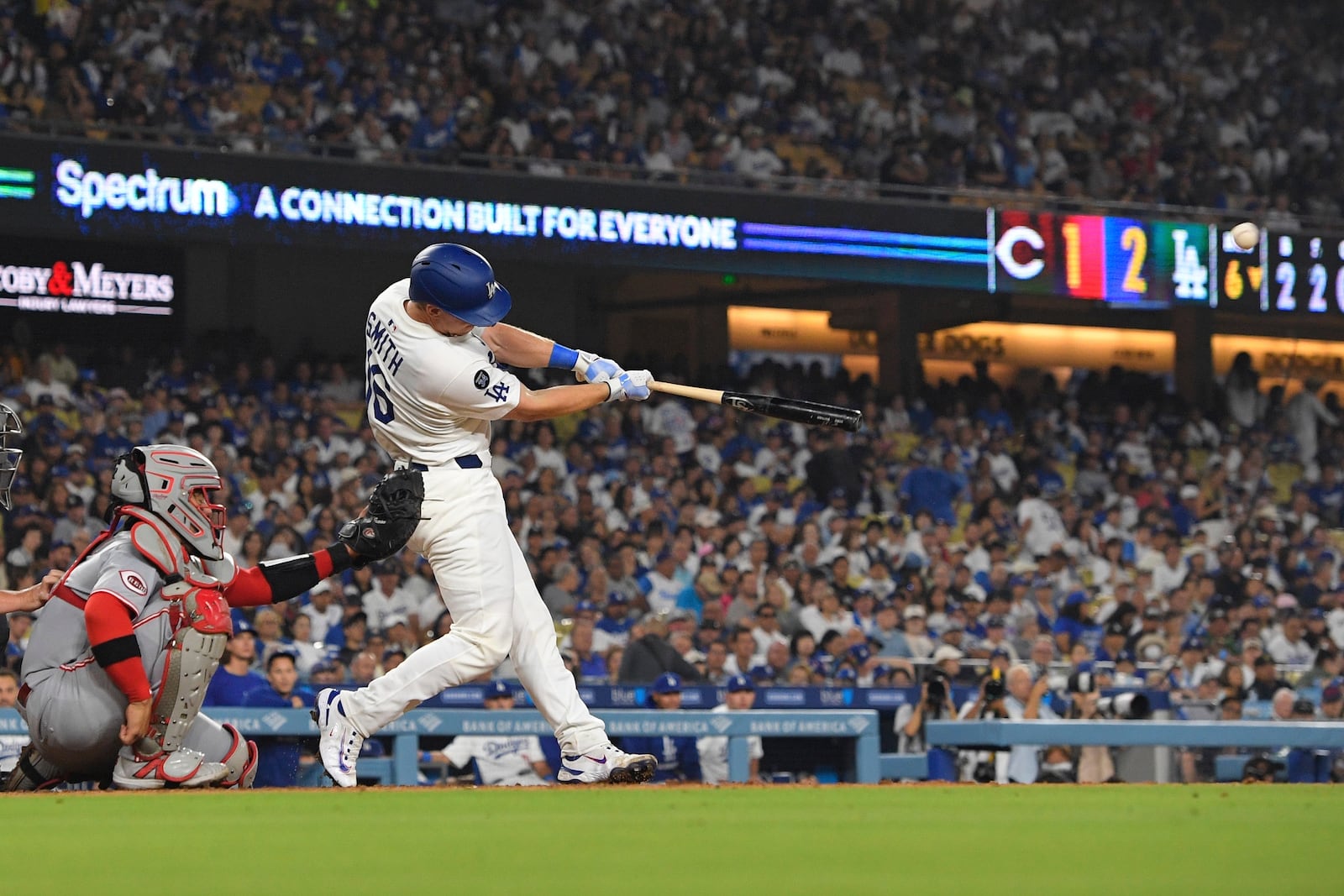 Los Angeles Dodgers' Will Smith, right, hits a solo home run as Cincinnati Reds catcher Jose Trevino watches during the sixth inning of a baseball game Tuesday, Aug. 26, 2025, in Los Angeles. (AP Photo/Mark J. Terrill)