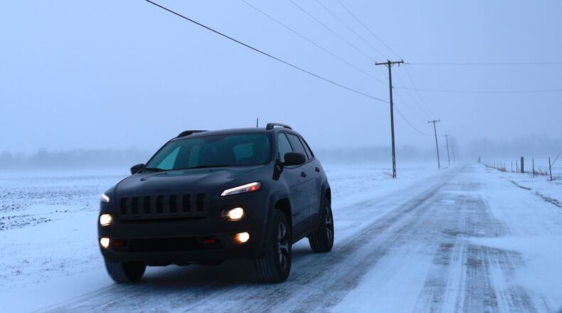 A car travels slowly along Snyder Road in Clark County where snow had drifted over the road in several spots Friday, Dec. 23, 2022. BILL LACKEY/STAFF