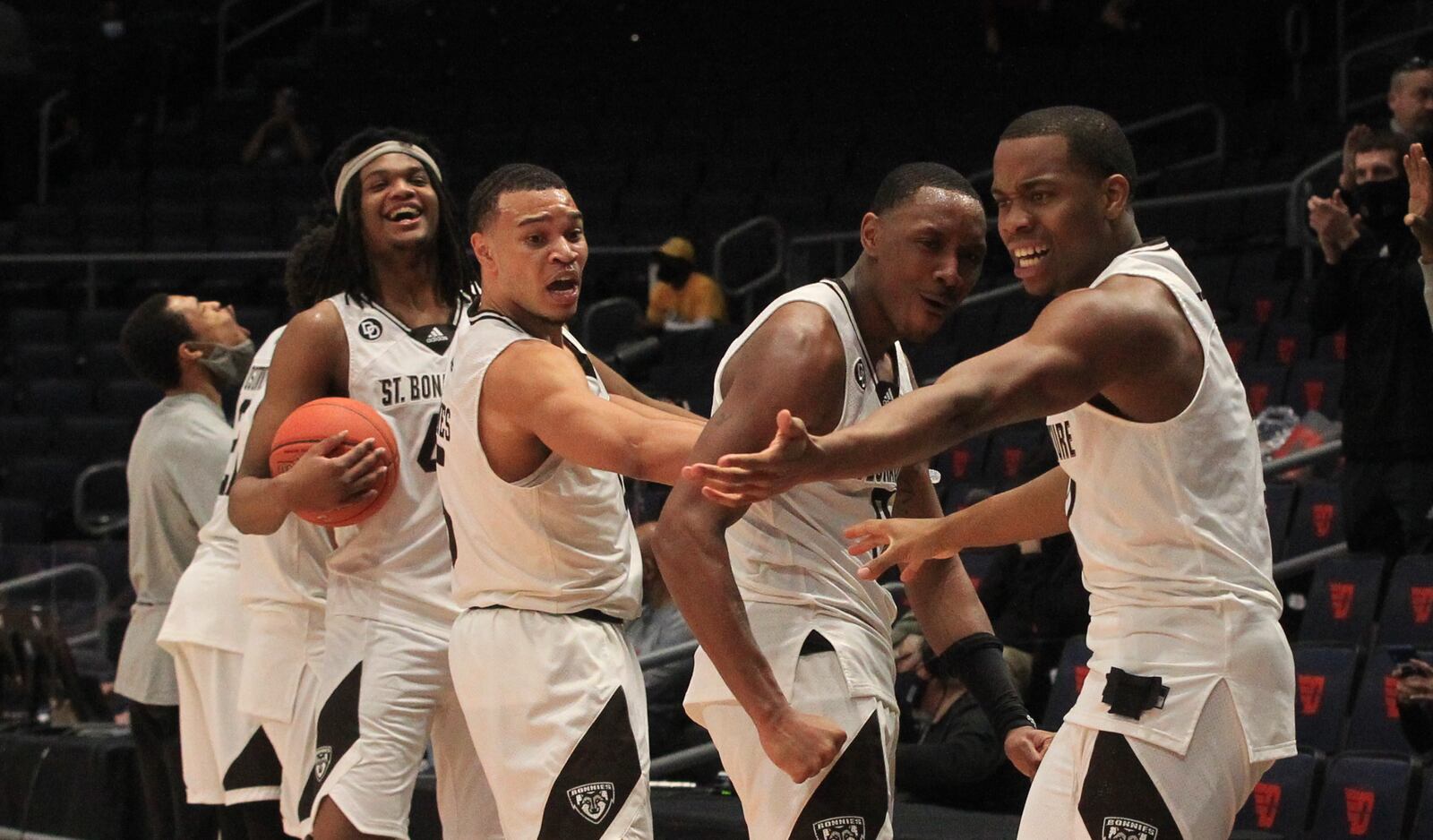 St. Bonaventure players react as a team videographer is restrained by a UD Arena security guard while the team celebrated the A-10 championship on Sunday, March 14, 2021. David Jablonski/Staff