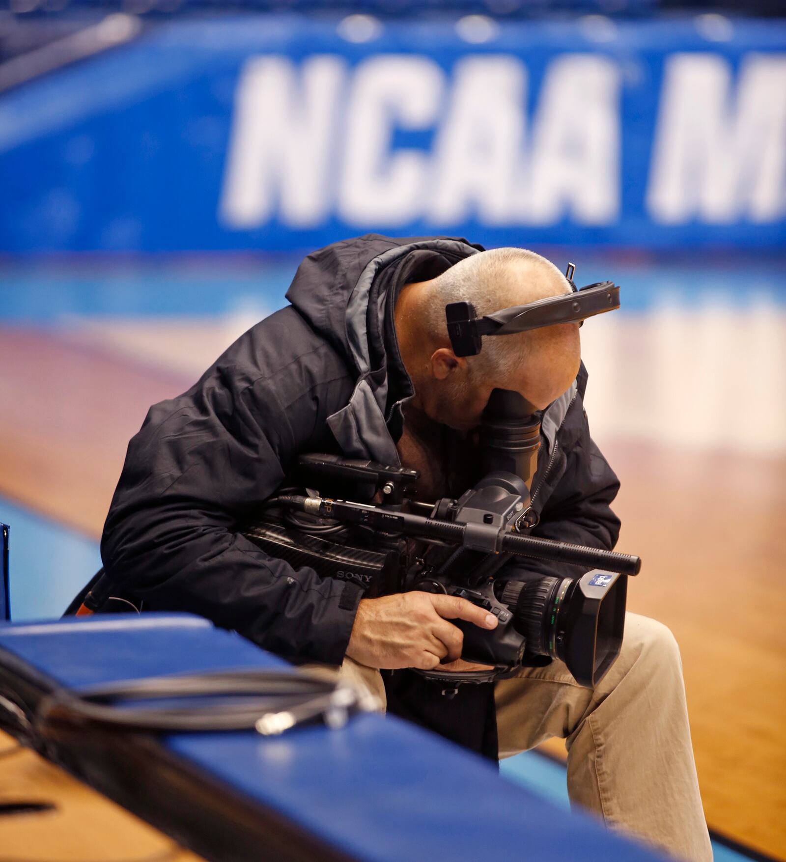 CBS photographer Jason Dutcher runs his camera before the practices started for the NCAA Tournament First Four at UD Arena on Monday night.  TY GREENLEES / STAFF