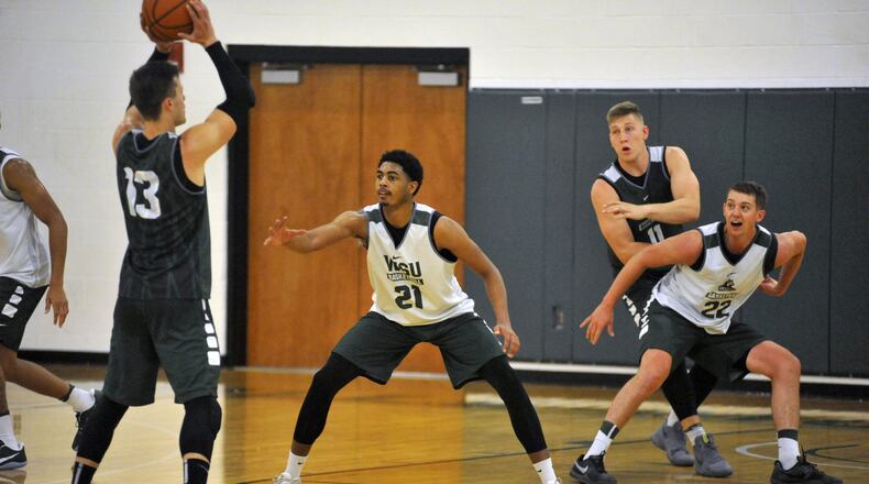 Wright State freshman James Manns (21) defends against senior Grant Benzinger during summer practice Thursday at the Stelzer Pavilion. JAY MORRISON / STAFF