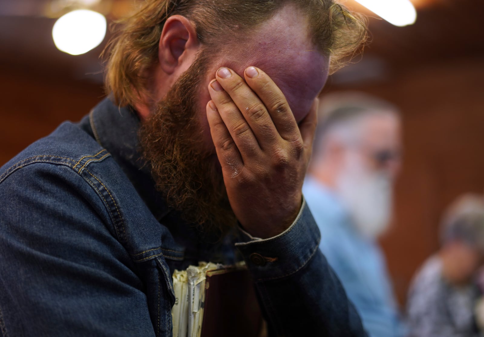 Isaac Green, 34, covers his eyes while praying before a Sacred Harp singing event at Holly Springs Primitive Baptist Church in Bremen, Ga., on Sunday, March 23, 2025. (AP Photo/Jessie Wardarski)