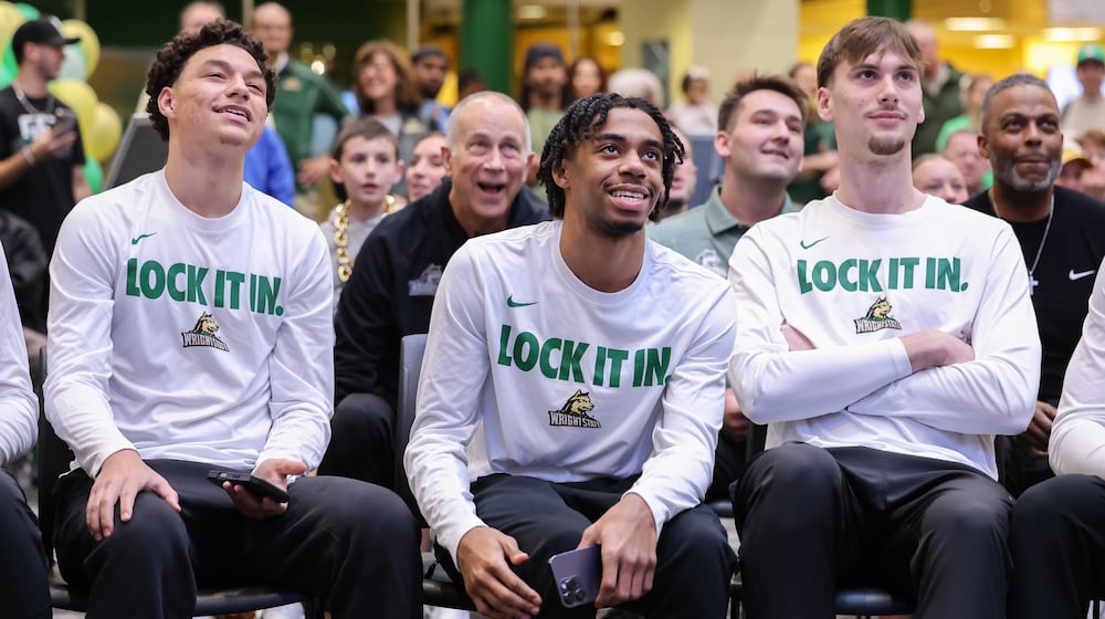 From left to right, Wright State's Michael Cooper, TJ Burch and Kellen Pickett react to a selection during a Selection Sunday watch party on Sunday, March 15 at the university's Student Union in Fairborn. BRYANT BILLING / STAFF