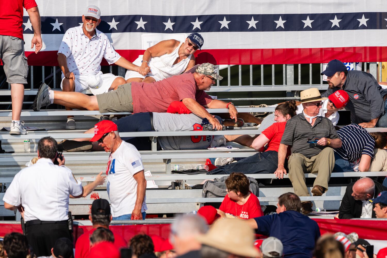 People seek cover after shots are fired at a campaign rally for former President Donald Trump in Butler, Pa., July 13, 2024.  (Eric Lee/The New York Times)
