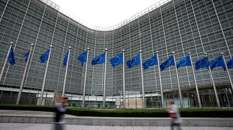 FILE - European Union flags flap in the wind as pedestrians walk by EU headquarters in Brussels, Wednesday, Sept. 20, 2023. (AP Photo/Virginia Mayo, File)