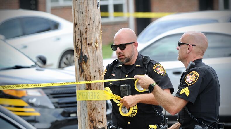 Montgomery County Sheriff's deputies stretch yellow crime scene tape around a utility pole after a boy was shot Wednesday, June 8, 2022, on Republic Drive in Harrison Twp. MARSHALL GORBY/STAFF