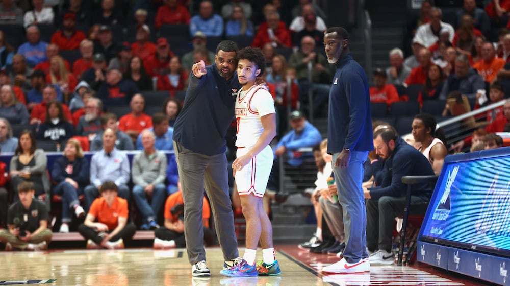 Dayton's Ricardo Greer, left, talks to Javon Bennett as Anthony Grant watches during an exhibition game against Bowling Green on Monday, Oct. 27, 2025, at UD Arena. David Jablonski/Staff