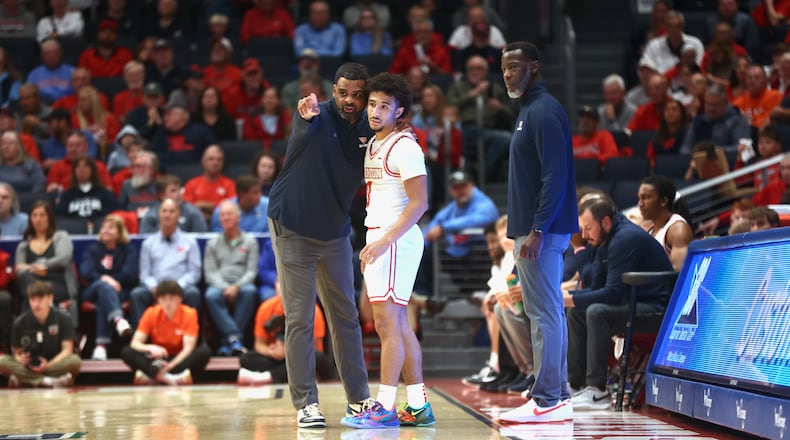 Dayton's Ricardo Greer, left, talks to Javon Bennett as Anthony Grant watches during an exhibition game against Bowling Green on Monday, Oct. 27, 2025, at UD Arena. David Jablonski/Staff