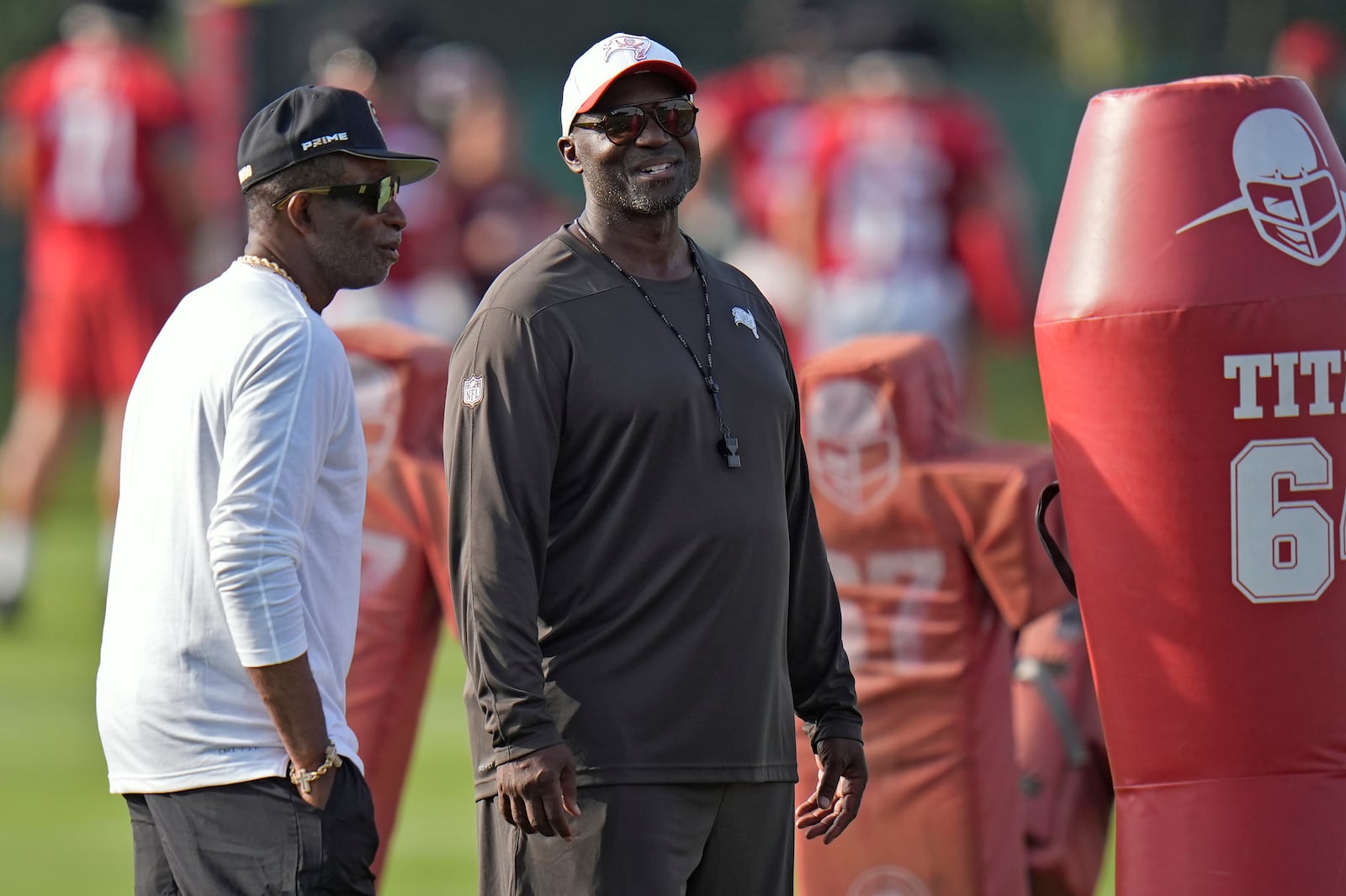 Tampa Bay Buccaneers head coach Todd Bowles, right, talks to Colorado head coach Deion Sanders during an NFL football training camp practice Wednesday, July 23, 2025, in Tampa, Fla. (AP Photo/Chris O'Meara)