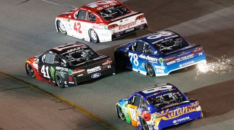 NASCAR Cup Series driver Martin Truex Jr. (78) trails sparks in Turn 2 along with Kurt Busch (41), Kyle Larson (42) and Kyle Busch (18) during the Monster Energy Series auto race at Richmond International Raceway in Richmond, Va., Saturday, Sept. 9, 2017. (AP Photo/Steve Helber)