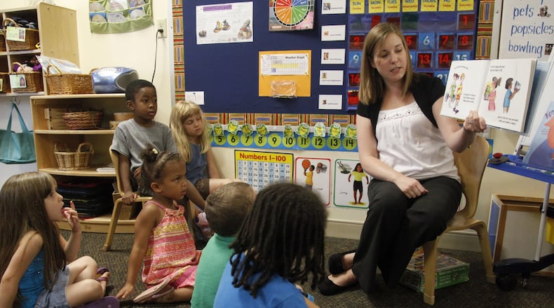 Stephanie Williams, a teacher at Miami Valley Hospital Child Care Center in Dayton, reads to her class of pre-kindergarten students. The center is run by Mini University. LISA POWELL / STAFF