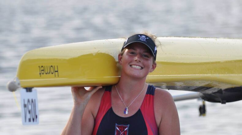 Troy Christian senior Megan Hinkle hoists her boat on her shoulders after a race in Chattanooga, Tenn., last year. CONTRIBUTED PHOTO