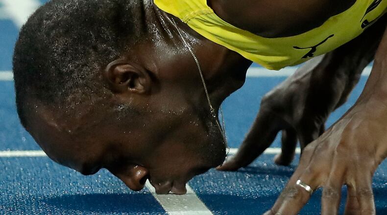 Usain Bolt from Jamaica kisses the track, after crossing the line to win the gold medal in the men's 200-meter final, during the athletics competitions of the 2016 Summer Olympics at the Olympic stadium in Rio de Janeiro, Brazil, Thursday, Aug. 18, 2016. (AP Photo/Matt Dunham)
