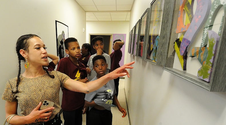 Maiya T. Hodge, a teacher at the Dayton Leadership Academies, shows fifth-graders on Friday May 12, 2023, the 3D pieces of art they created on display at the Five Rivers Health Centers Edgemont Campus. MARSHALL GORBY\STAFF