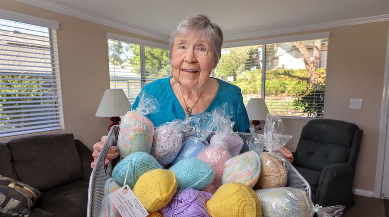 Pat Anderson holds a basket full of her various “Busters” wardrobe accessories for breast cancer survivors. (Charlie Neuman/San Diego Union-Tribune/TNS)