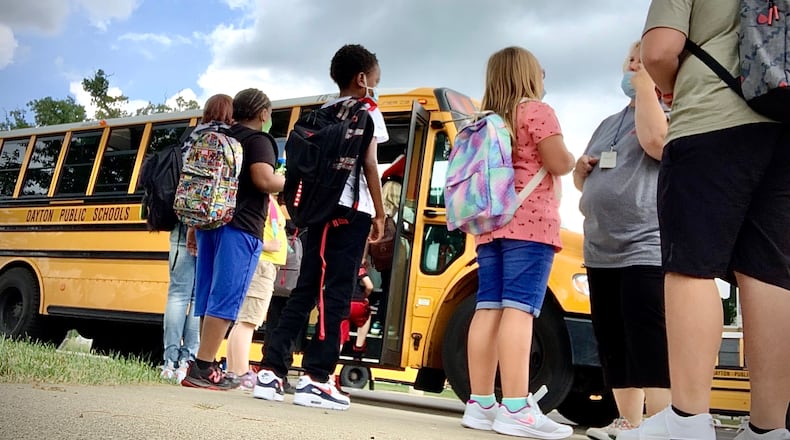 Students wait to get on the school bus at Eastmont elementary school Wednesday Aug. 18, 2021 in Dayton. MARSHALL GORBY\STAFF
