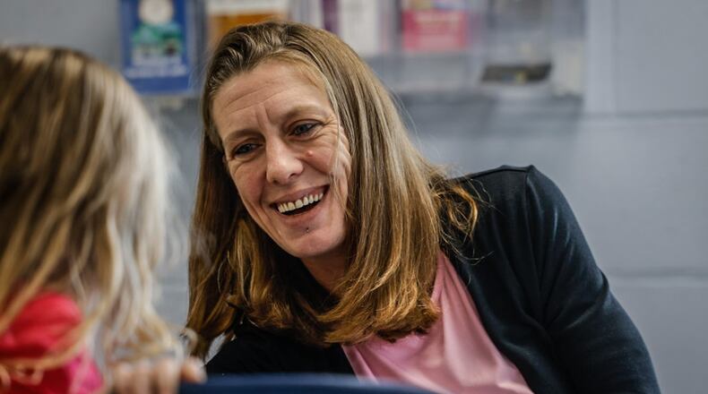Community health worker for the House of Bread, Taraisa Fecke, talks with a child at the facility. JIM NOELKER/STAFF