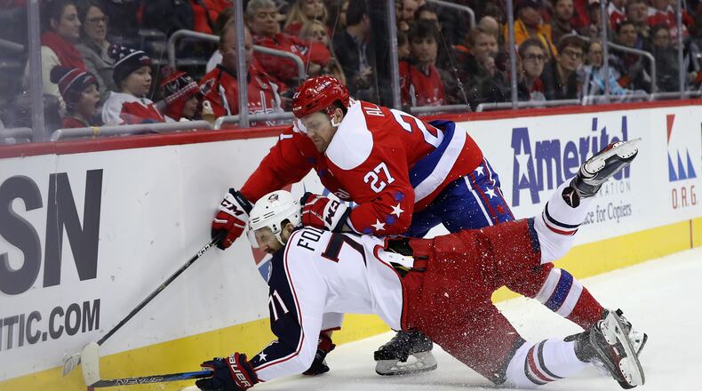 WASHINGTON, DC - JANUARY 05: Nick Foligno #71 of the Columbus Blue Jackets and Karl Alzner #27 of the Washington Capitals go after the puck in the first period at Verizon Center on January 5, 2017 in Washington, DC. (Photo by Rob Carr/Getty Images)