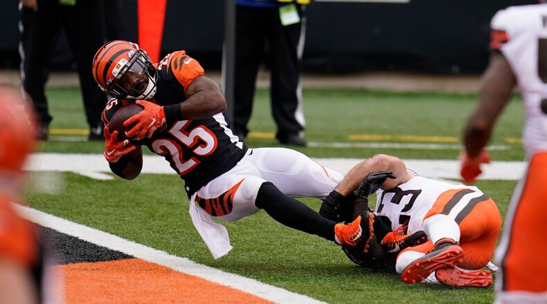 Cincinnati Bengals' Giovani Bernard (25) goes in for a touchdown while being tackled by Cleveland Browns' Andrew Sendejo (23) during the second half of an NFL football game, Sunday, Oct. 25, 2020, in Cincinnati. (AP Photo/Michael Conroy)