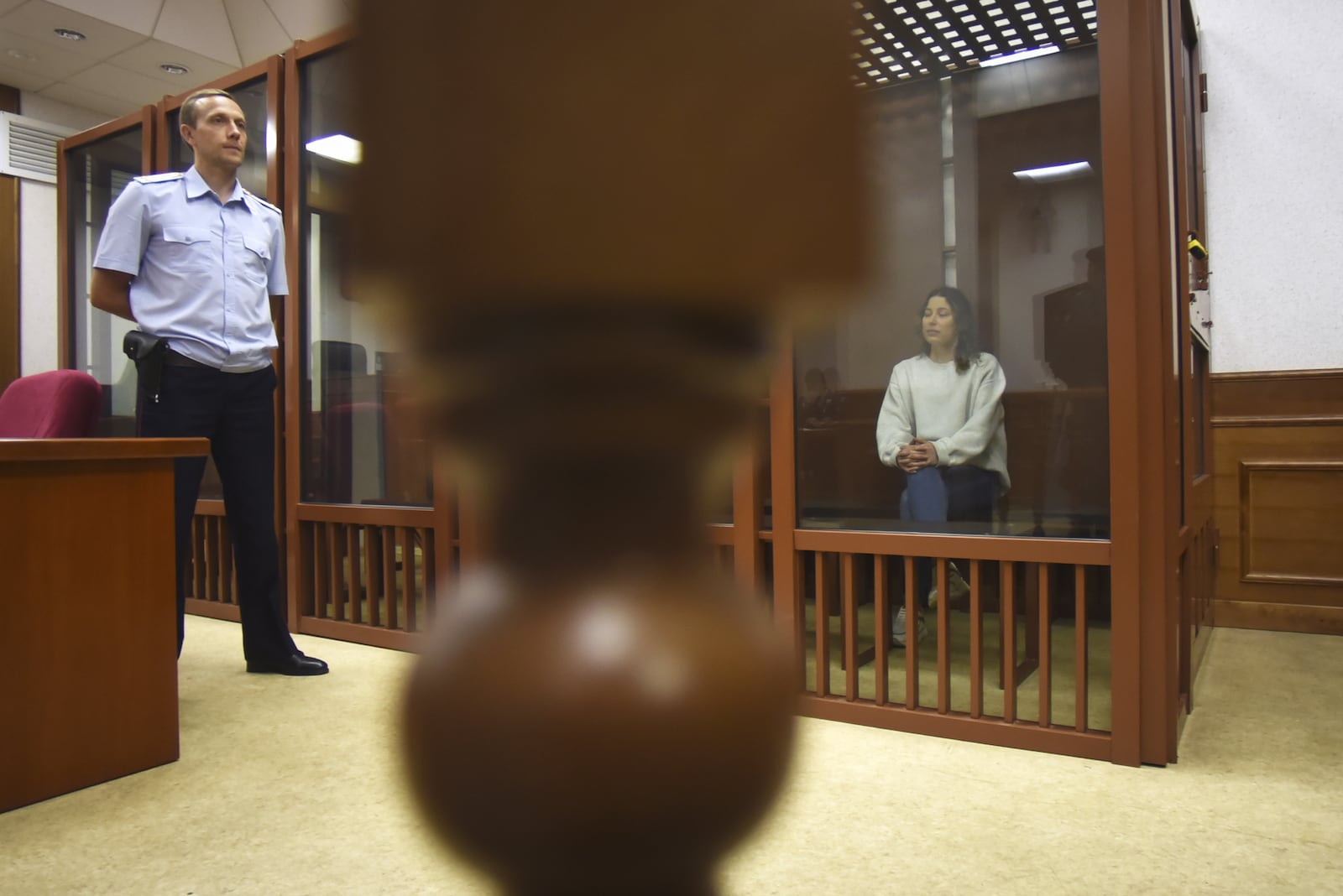 FILE - Ksenia Karelina sits in a glass cage in a court room in Yekaterinburg, Russia, Aug. 15, 2024. (AP Photo, File)