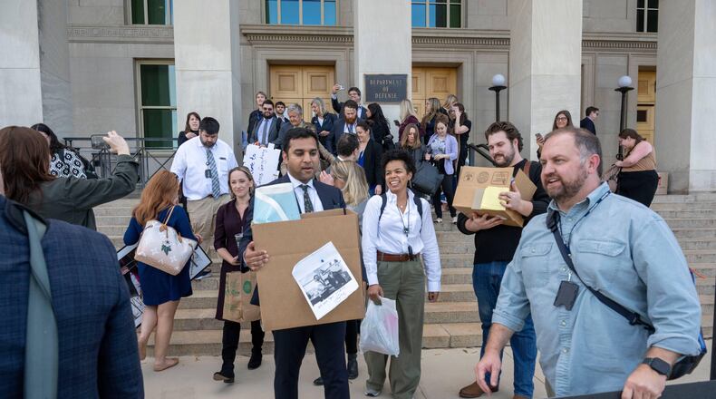 Members of the Pentagon press corp carry their belongings out of the Pentagon after turning in their press credentials, Wednesday, Oct. 15, 2025 in Washington. (AP Photo/Kevin Wolf)