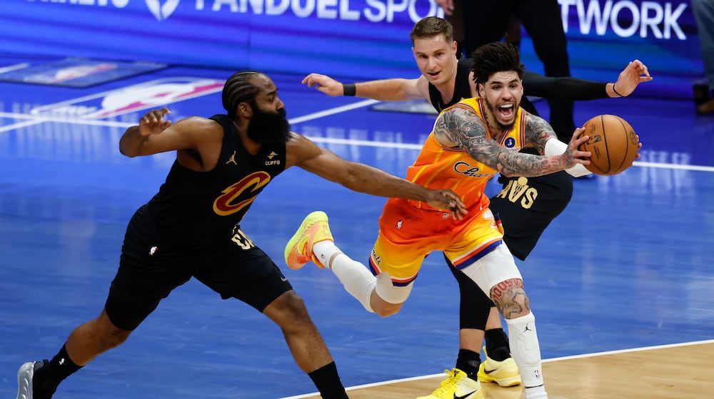 Charlotte Hornets guard LaMelo Ball, front right, drives between Cleveland Cavaliers guards James Harden, left, and Sam Merrill, back right, during the first half of an NBA basketball game in Charlotte, N.C., Friday, Feb. 20, 2026. (AP Photo/Nell Redmond)